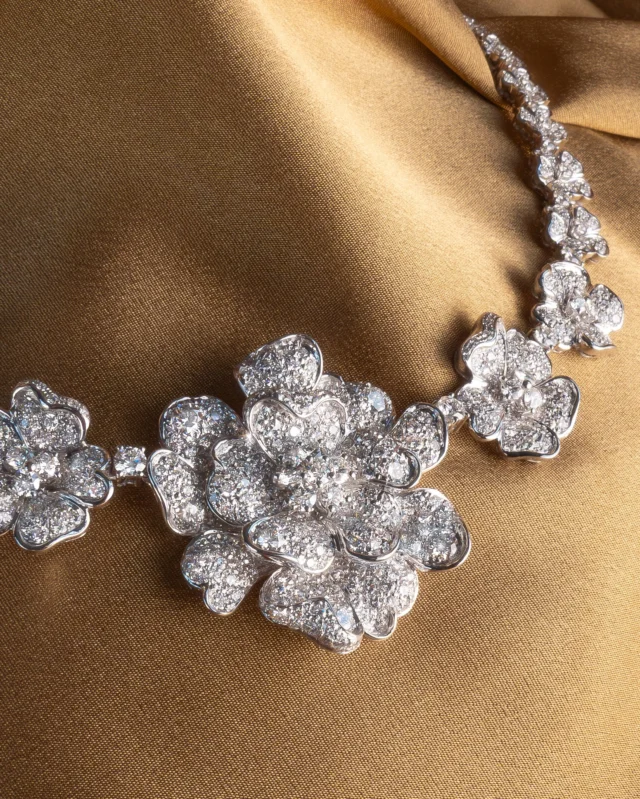 The Flora necklace blooms in all its magnificence: crafted in 18k white gold and illuminated by 17.2 carats of pavé-set natural diamonds, this extraordinary creation transforms every petal into a celebration of elegance, artistry, and pure emotion.
A masterpiece that doesn’t follow the light. It creates it.

Collezione Flora 30005B