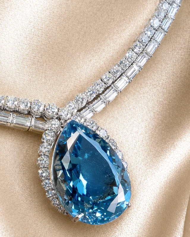 The magnificent necklace crafted in 18-carat white gold, distinguished by its extraordinary pear-cut aquamarine center stone weighing over 25 carats.
Surrounding this absolute protagonist gemstone, a sophisticated interplay of volumes and reflections comes to life through 100 natural baguette-cut diamonds and 165 natural brilliant-cut diamonds.
The two diamond strands gracefully adorning the neck flow in perfect balance of luminosity and movement, creating a visual symphony of extraordinary elegance. This is where the new Sinfonia Collection takes its name from, resulting in a masterpiece of art and Italian craftsmanship.

Collezione Sinfonia 29174BA